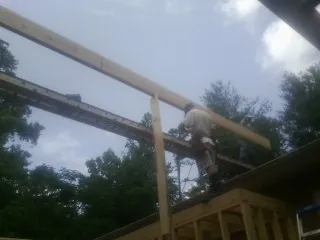 Carpenter setting a ridge beam over a new addition frame — Ice Dam Removal by Roofing Brothers in Buchanan Dam