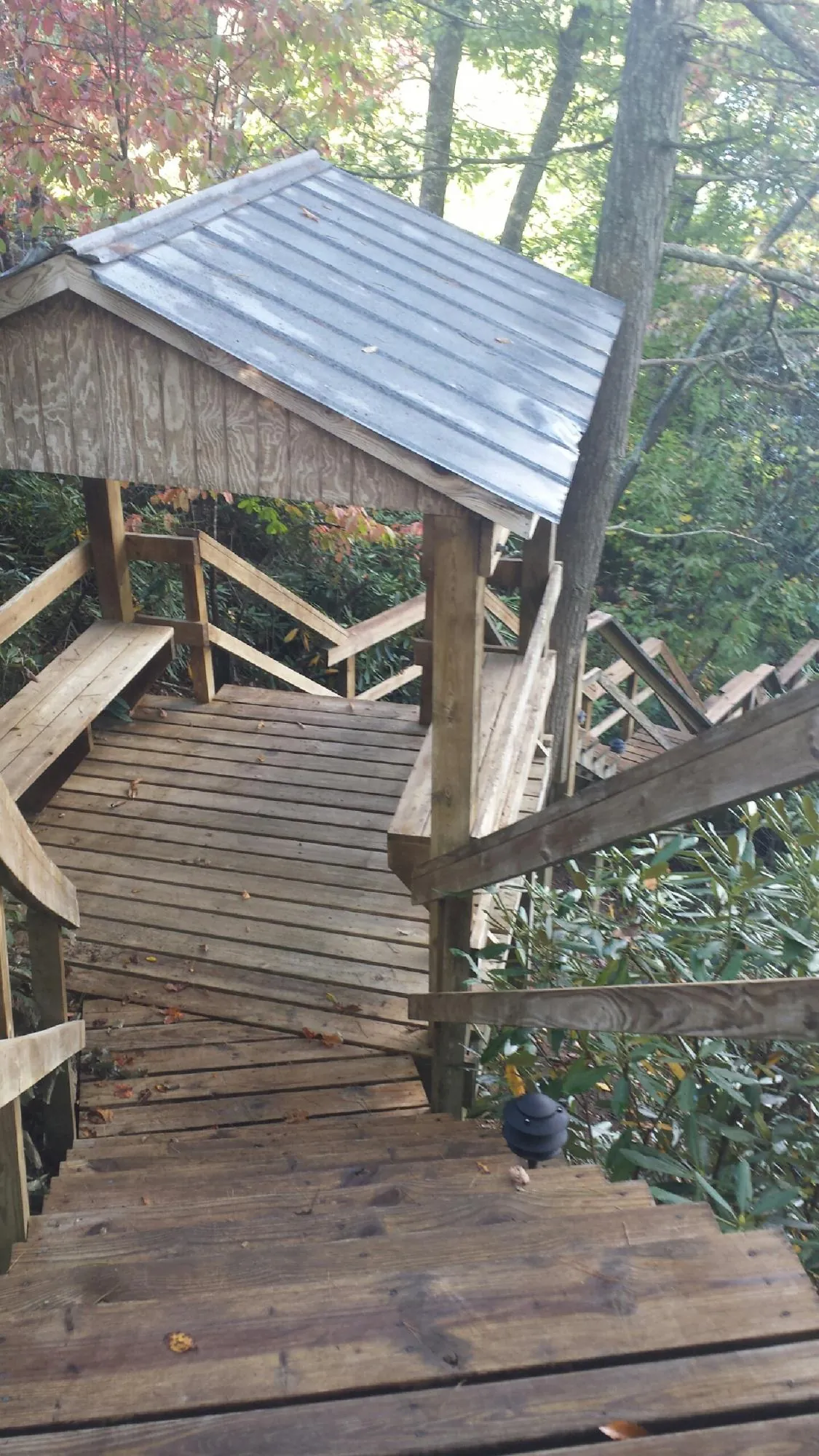 Metal roofed shelter over wooden steps on a wooded walkway — Skylight Repair & Installation work by our crew in Buchanan Dam