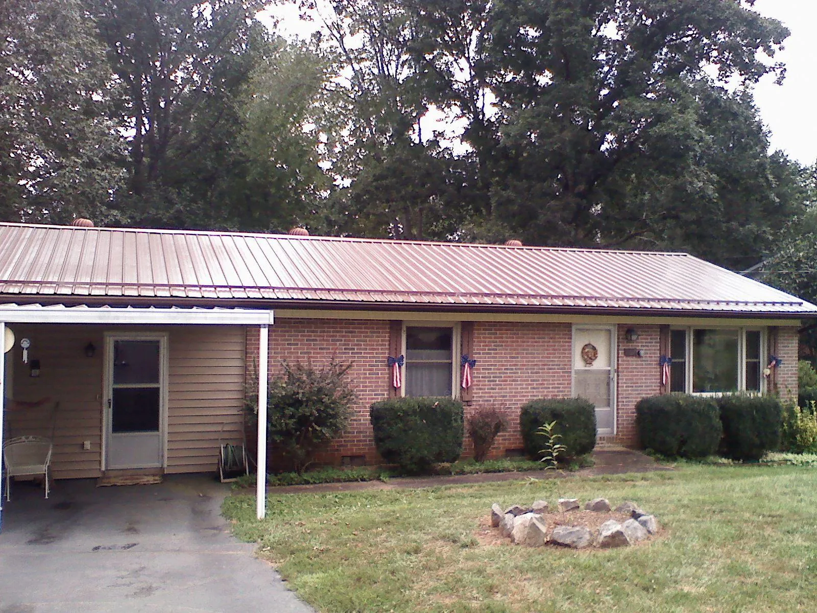 Bronze metal roof and carport on a brick ranch home — Roof Repair work by our crew in Buchanan Dam