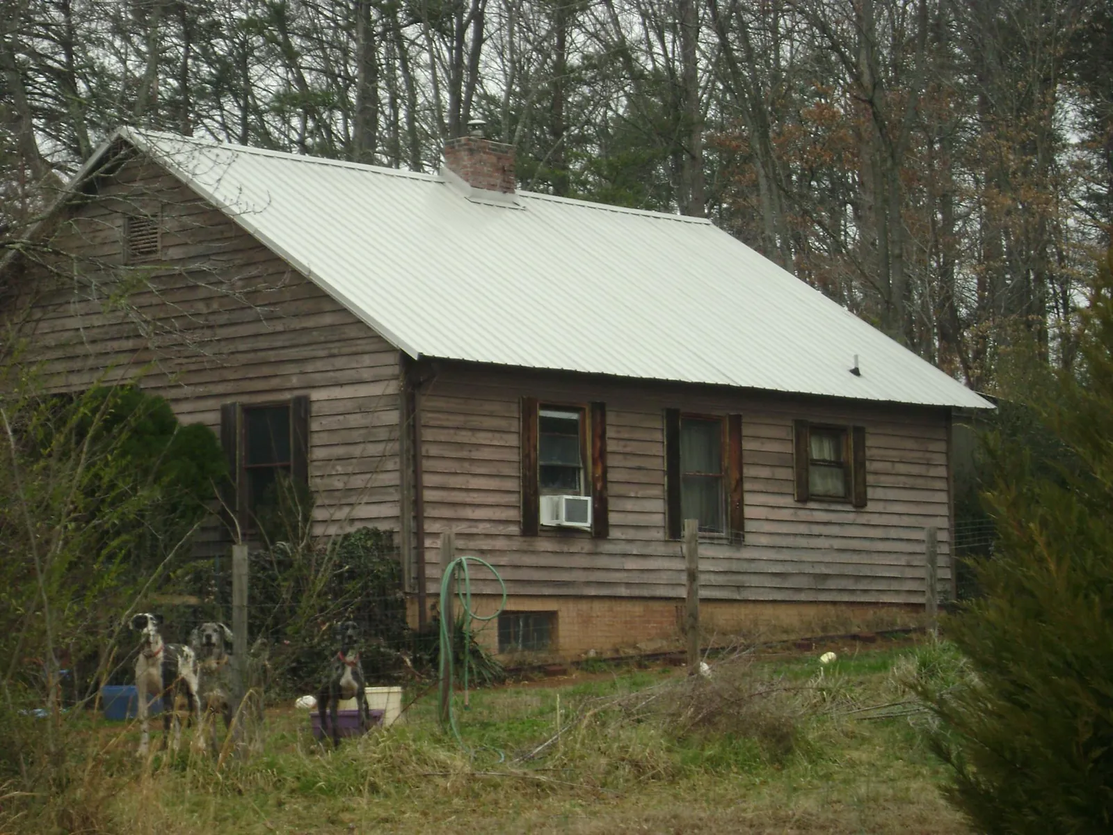 White metal roof on an old wood sided farmhouse, from a Metal Roof Installation job in Buchanan Dam